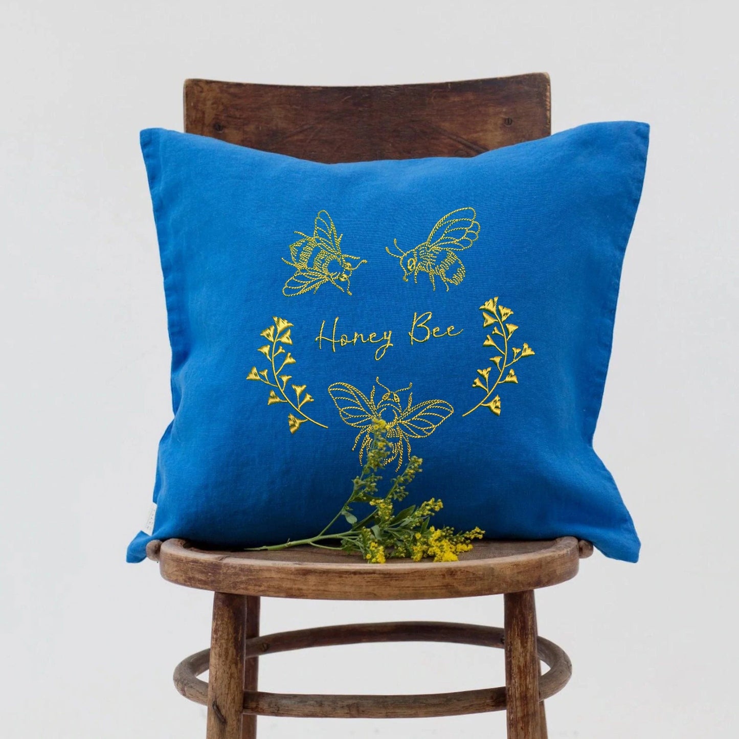 Honey Bee Machine Embroidery Design on a blue pillow